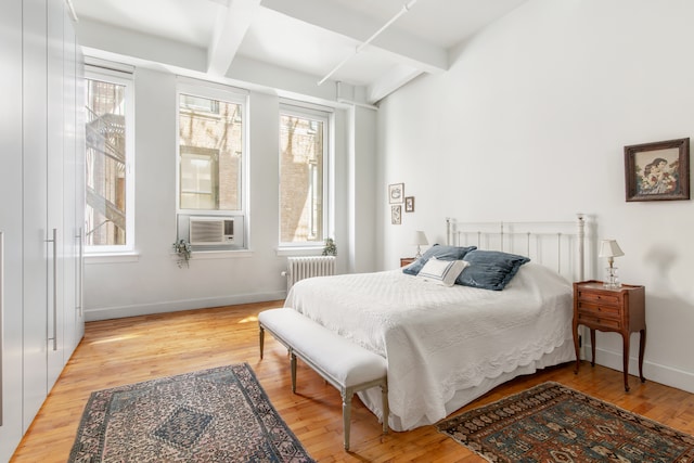 109 W 26th St Unit 8B, New York City, NY 10001 - bedroom featuring multiple windows, radiator heating unit, beam ceiling, baseboards, and light wood-style floors