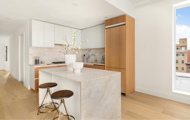 684 Dean St Unit 2, New York City, NY 11238 - kitchen featuring light wood-style floors, backsplash, a kitchen breakfast bar, and modern cabinets