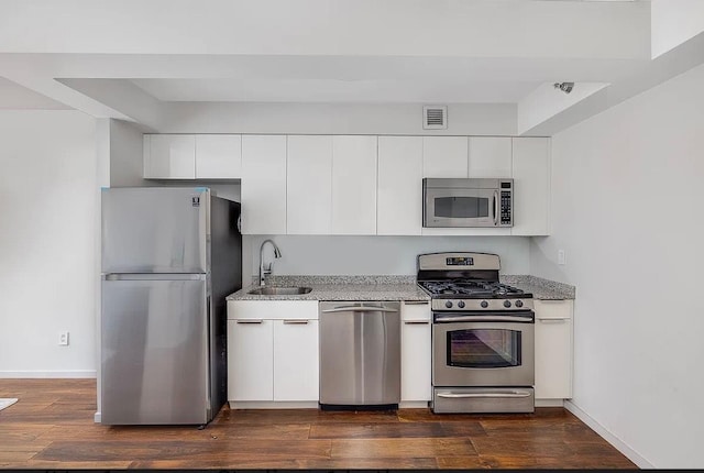 516 W 47th St Unit N-4D, New York City, NY 10036 - kitchen featuring appliances with stainless steel finishes, a sink, white cabinetry, and dark wood-style flooring