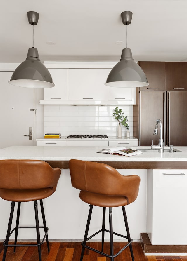 125 N 10th St Unit N2D, New York City, NY 11249 - kitchen with high end refrigerator, tasteful backsplash, a breakfast bar, gas cooktop, and hanging light fixtures