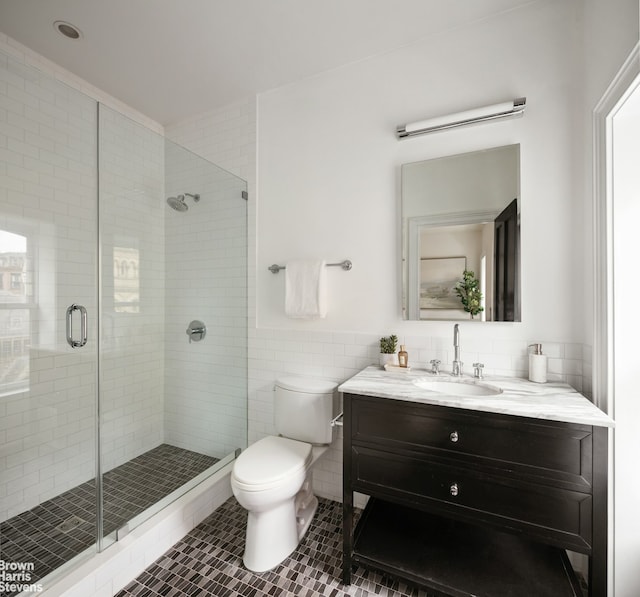 272 Lafayette Ave, New York City, NY 11238 - bathroom with tile patterned floors, vanity, tile walls, a shower stall, and a wainscoted wall