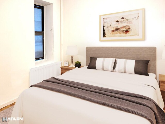 157 W 123rd St Unit 2H, New York City, NY 10027 - bedroom featuring radiator heating unit and wood finished floors