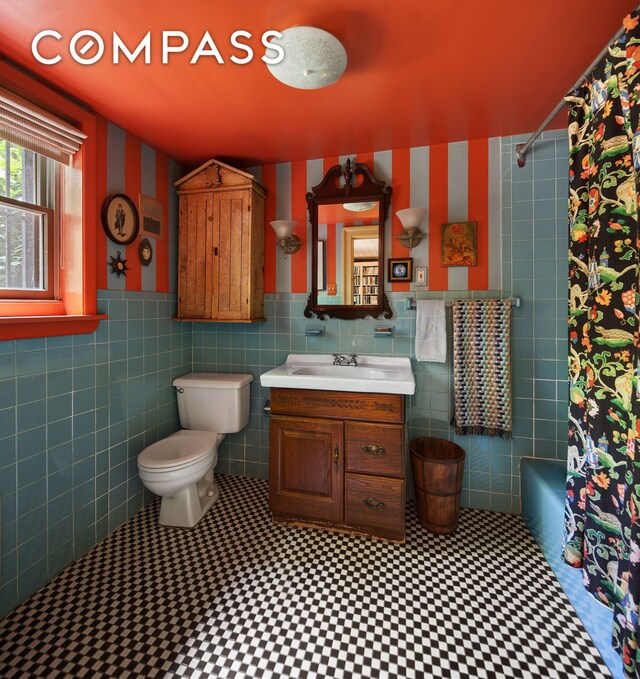433 Pacific St, New York City, NY 11217 - full bathroom featuring vanity, tile walls, shower / bathtub combination with curtain, and wainscoting