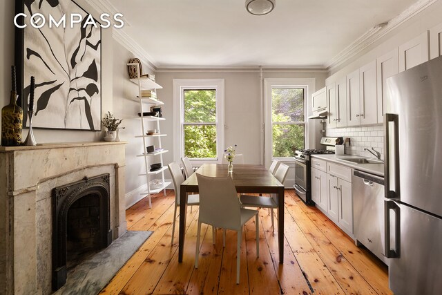 433 Pacific St, New York City, NY 11217 - dining space featuring crown molding, light wood-style flooring, and a high end fireplace
