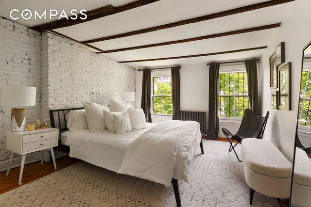433 Pacific St, New York City, NY 11217 - bedroom featuring light wood finished floors, beamed ceiling, radiator heating unit, and brick wall