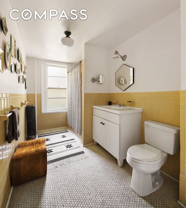 433 Pacific St, New York City, NY 11217 - bathroom featuring tile walls, wainscoting, tile patterned floors, a tile shower, and vanity