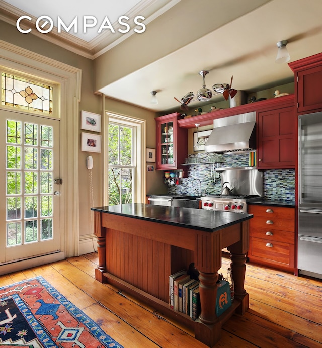 433 Pacific St, New York City, NY 11217 - kitchen with wall chimney exhaust hood, crown molding, tasteful backsplash, dark countertops, and high quality fridge
