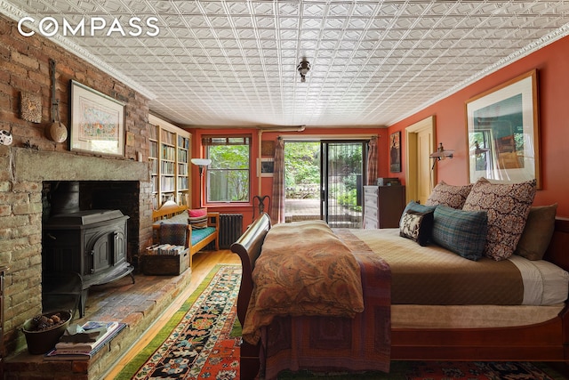 433 Pacific St, New York City, NY 11217 - bedroom with a wood stove, an ornate ceiling, wood finished floors, access to outside, and ornamental molding
