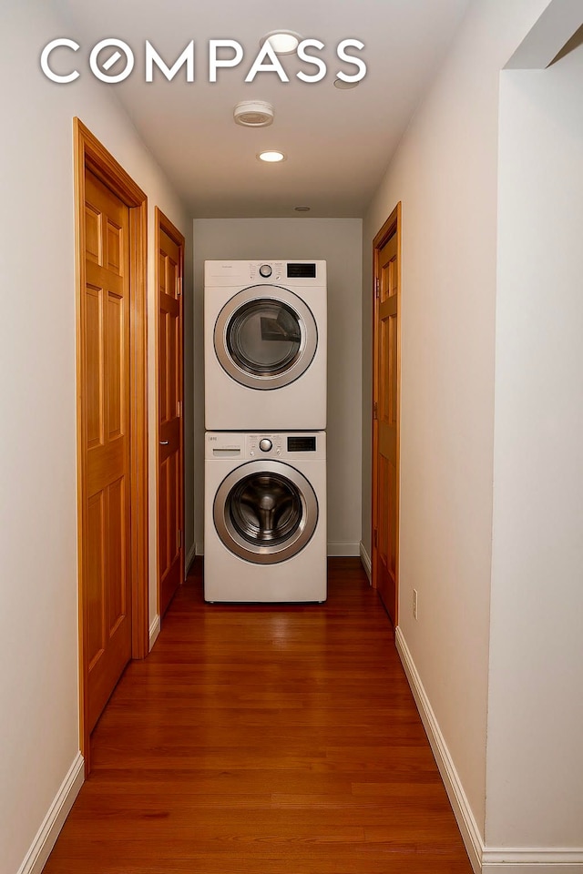 31 Monroe St Unit 9B, New York City, NY 10002 - washroom featuring stacked washing machine and dryer, wood finished floors, baseboards, and recessed lighting