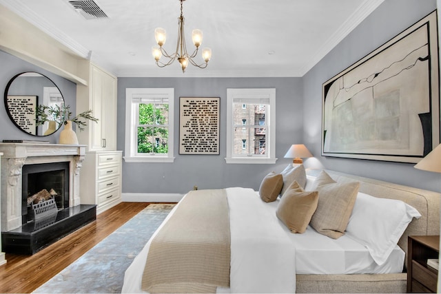 307 E 87th St, New York City, NY 10128 - bedroom featuring wood finished floors, a chandelier, crown molding, baseboards, and a fireplace