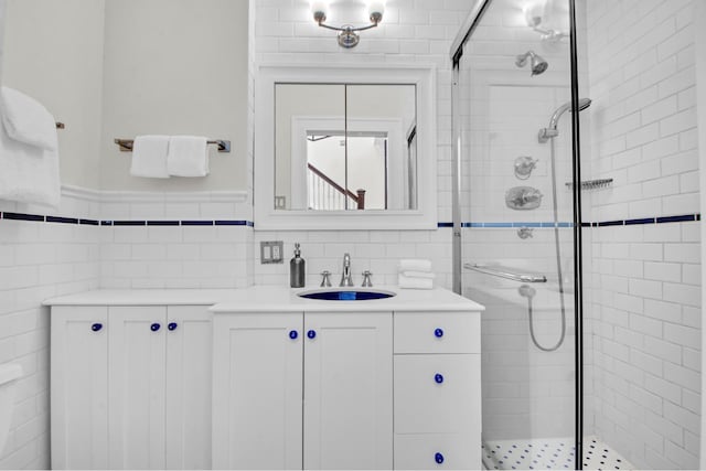 307 E 87th St, New York City, NY 10128 - bathroom featuring a shower stall, vanity, tile walls, and a wainscoted wall