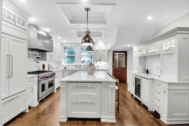 307 E 87th St, New York City, NY 10128 - kitchen with range with two ovens, wine cooler, a tray ceiling, light countertops, and ornamental molding