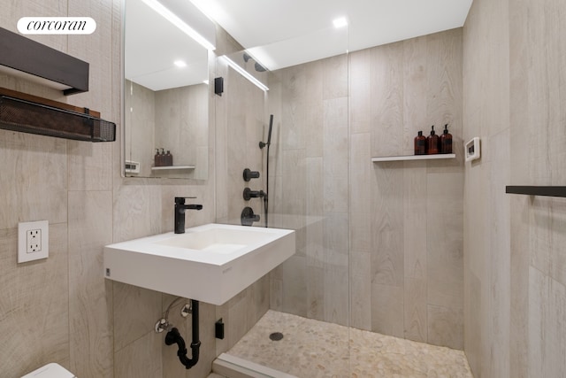 200 E 58th St Unit 12A, New York City, NY 10022 - bathroom featuring tiled shower, a sink, and toilet