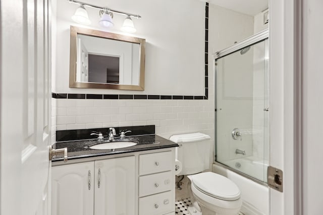 300 E 40th St Unit 6X, New York City, NY 10016 - bathroom featuring tile walls, vanity, shower / bath combination with glass door, and a wainscoted wall