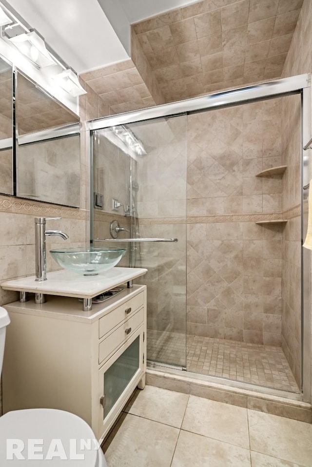 235 E 57th St Unit 14C, New York City, NY 10022 - full bathroom with toilet, vanity, a shower stall, tile walls, and tile patterned floors