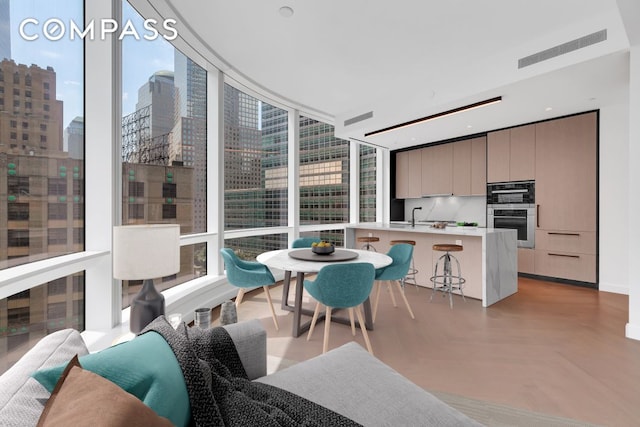 111 Murray St Unit 11C, New York City, NY 10007 - kitchen with modern cabinets, a breakfast bar area, light countertops, a view of city, and healthy amount of natural light