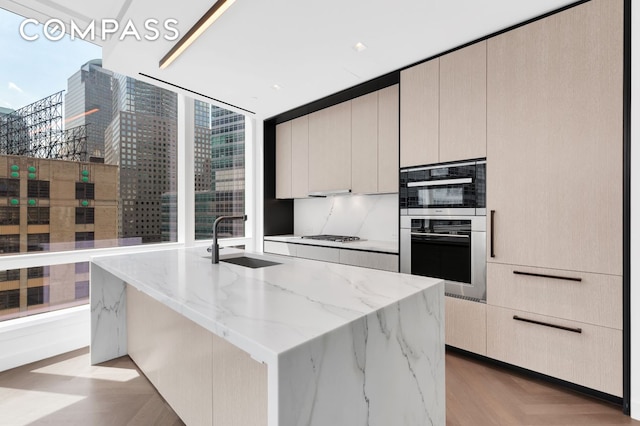 111 Murray St Unit 11C, New York City, NY 10007 - kitchen featuring a sink, light stone counters, stainless steel appliances, and modern cabinets
