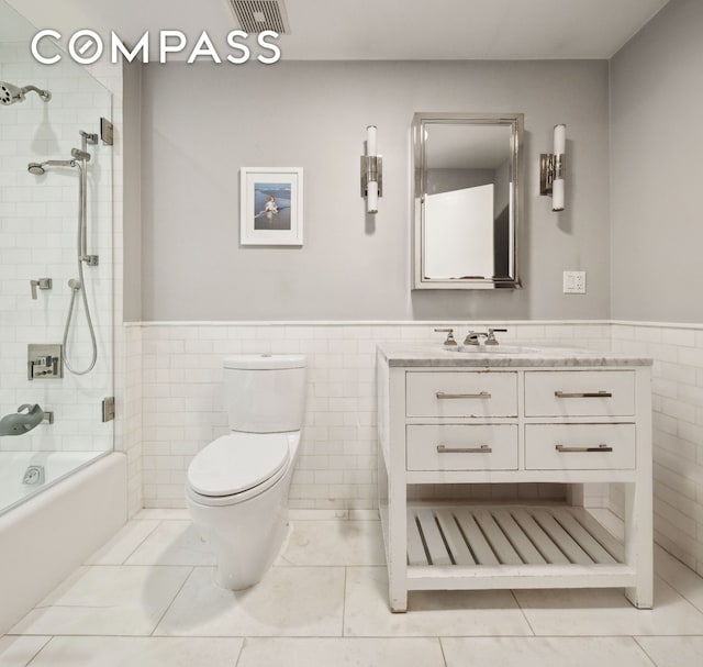 129 W 22nd St Unit 5A, New York City, NY 10011 - full bathroom with shower / tub combination, vanity, toilet, tile walls, and a wainscoted wall