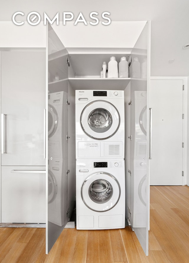 123 3rd Ave Unit 9C, New York City, NY 10003 - washroom featuring stacked washer and clothes dryer and light wood-style floors