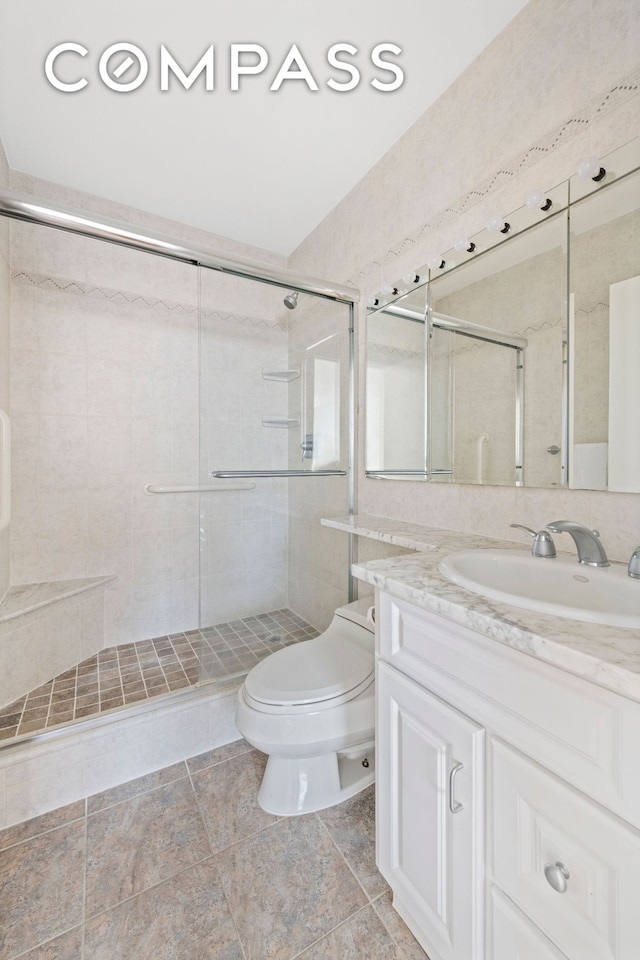 171 E 84th St Unit 31C, New York City, NY 10028 - bathroom featuring toilet, vanity, a stall shower, and tile patterned floors