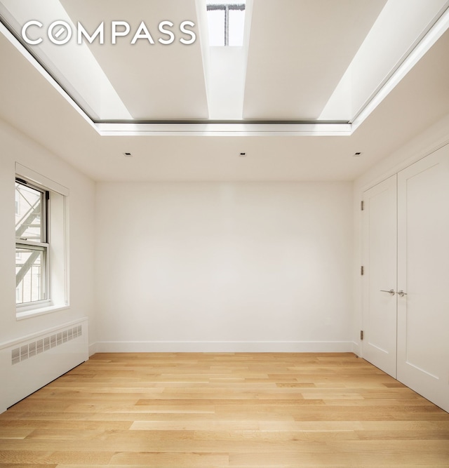 435 E 85th St Unit 4F, New York City, NY 10028 - empty room featuring radiator, light wood-type flooring, and baseboards
