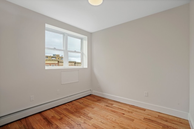 60-14 Menahan St, New York City, NY 11385 - empty room featuring a baseboard radiator and light wood-style flooring