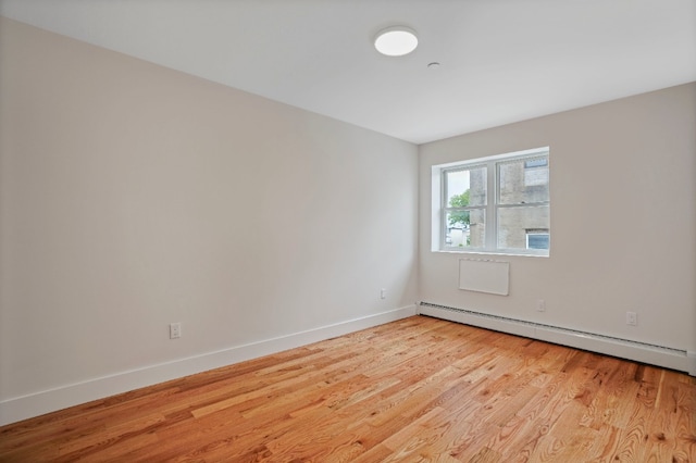 60-14 Menahan St, New York City, NY 11385 - unfurnished room with a baseboard heating unit and light wood-type flooring