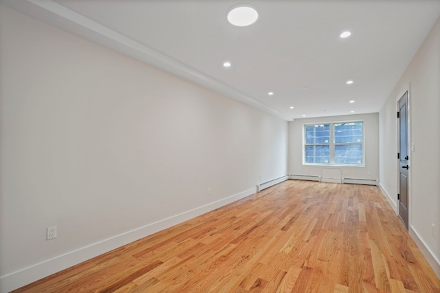 60-14 Menahan St, New York City, NY 11385 - empty room with light wood-style floors, a baseboard radiator, and recessed lighting