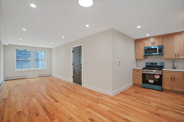 60-14 Menahan St, New York City, NY 11385 - kitchen featuring appliances with stainless steel finishes, light wood-type flooring, a baseboard heating unit, recessed lighting, and light countertops