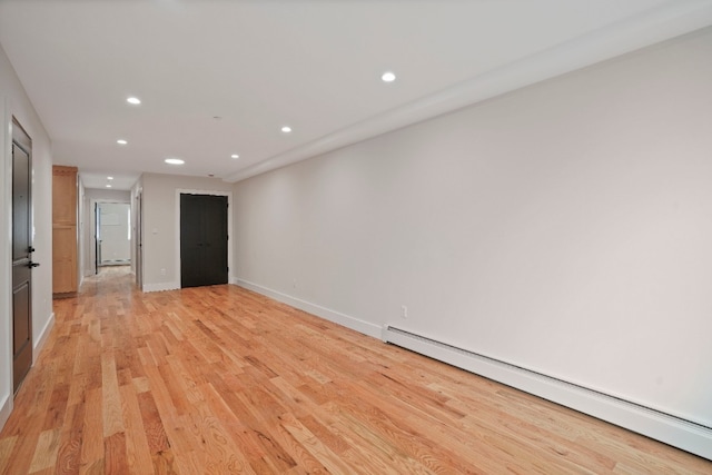 60-14 Menahan St, New York City, NY 11385 - empty room with a baseboard heating unit, recessed lighting, and light wood-type flooring