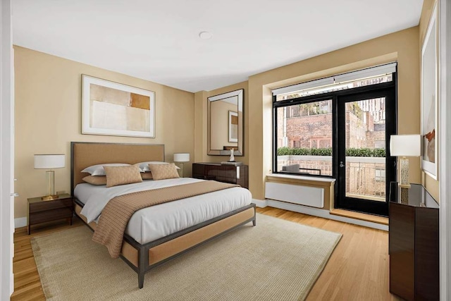 124 Hudson St Unit 6D, New York City, NY 10013 - bedroom with access to exterior, light wood-type flooring, and baseboards