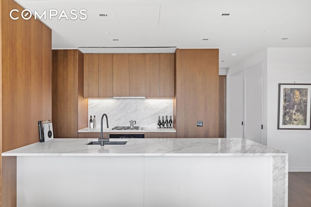 570 Broome St Unit 23A, New York City, NY 10013 - kitchen featuring brown cabinets, modern cabinets, light stone counters, and decorative backsplash