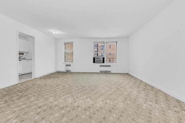 105-34 65th Ave Unit 4G, New York City, NY 11375 - empty room featuring radiator heating unit, carpet, baseboards, and a sink