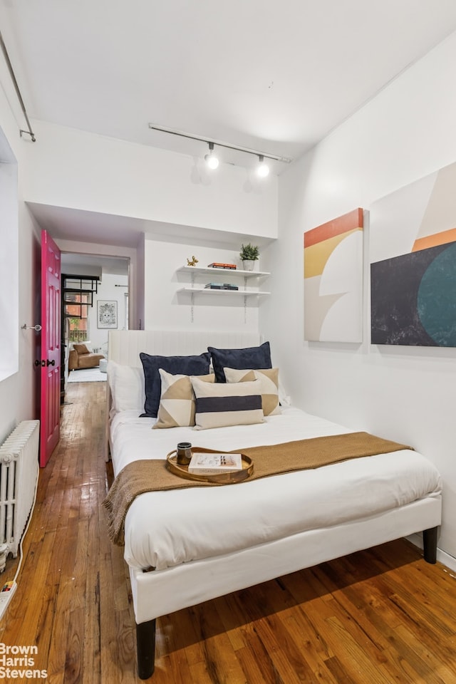 317 E 73rd St Unit 5Fe, New York City, NY 10021 - bedroom with track lighting, radiator, and wood-type flooring