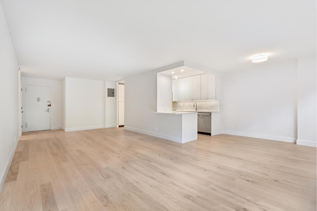 142 W End Ave Unit 2U, New York City, NY 10023 - unfurnished living room featuring light wood-type flooring, baseboards, and a sink