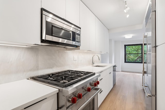 142 W End Ave Unit 2U, New York City, NY 10023 - kitchen featuring high end appliances, a sink, modern cabinets, and white cabinetry