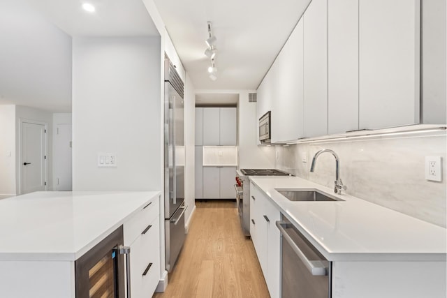 142 W End Ave Unit 2U, New York City, NY 10023 - kitchen with a sink, high quality appliances, wine cooler, light wood-style flooring, and white cabinets