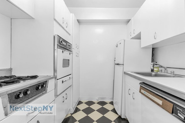 345 E 56th St Unit 20A, New York City, NY 10022 - kitchen with white appliances, light floors, a sink, and white cabinetry