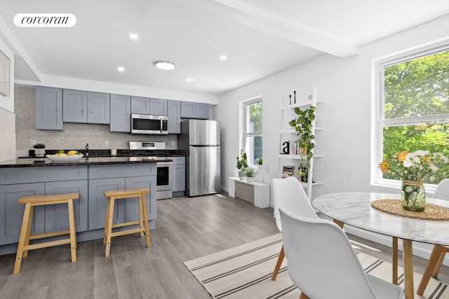 21 E 4th St, New York City, NY 11218 - kitchen featuring stainless steel appliances, decorative backsplash, light wood-style flooring, dark stone counters, and recessed lighting