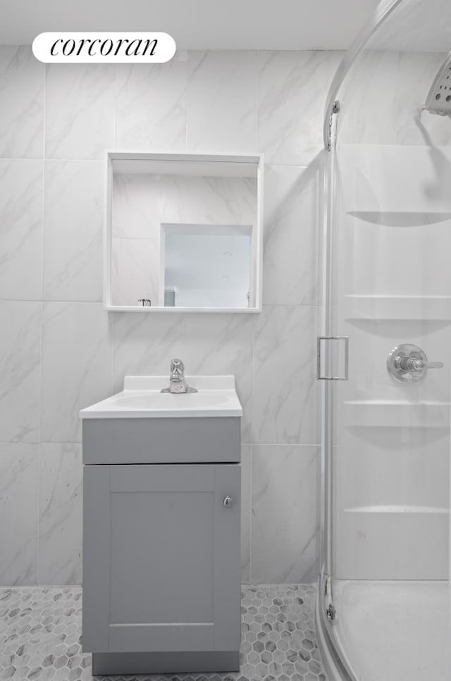 21 E 4th St, New York City, NY 11218 - full bath featuring a shower stall, vanity, tile patterned floors, and tile walls