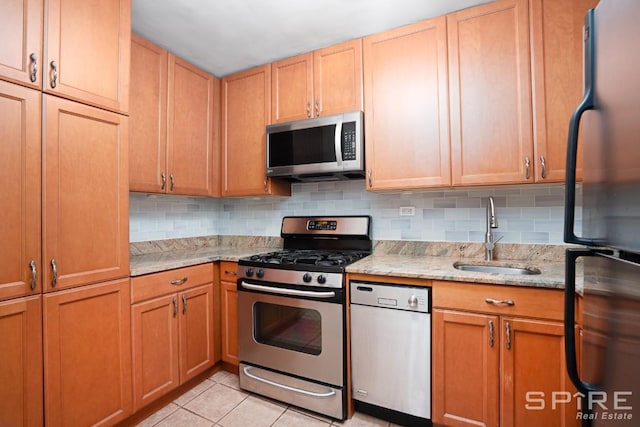 245 E 25th St Unit 6L, New York City, NY 10010 - kitchen featuring stainless steel appliances, light stone countertops, tasteful backsplash, and light tile patterned floors
