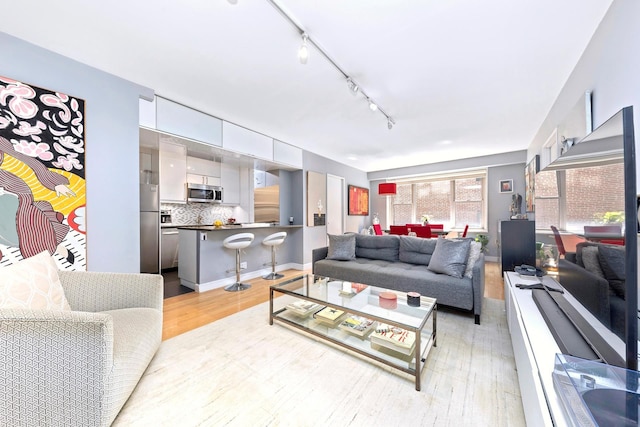 137 E 36th St Unit 5B, New York City, NY 10016 - living room featuring light wood-style flooring and rail lighting
