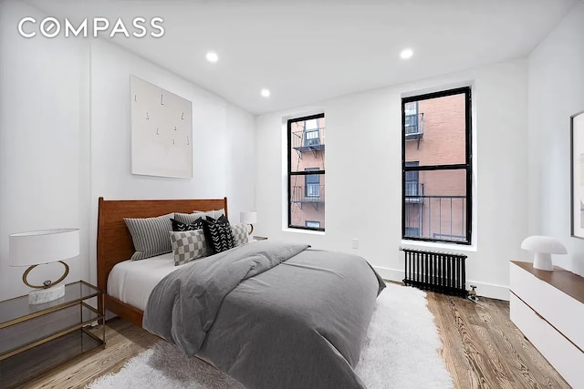 66 W 138th St Unit 1A, New York City, NY 10037 - bedroom featuring radiator heating unit, wood finished floors, and recessed lighting