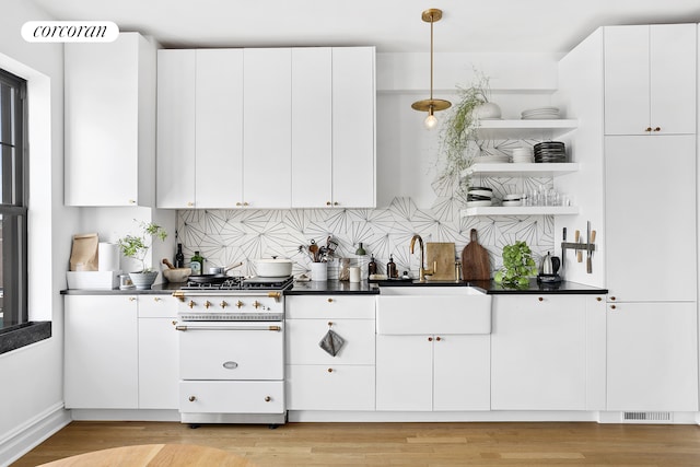 170 2nd Ave Unit 9B, New York City, NY 10003 - kitchen with range with two ovens, a sink, open shelves, white cabinetry, and light wood-style flooring