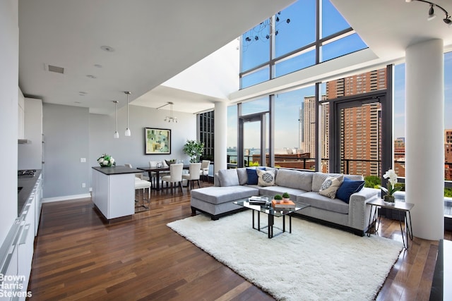 99 Warren St Unit 11C, New York City, NY 10007 - living area with dark wood-style floors, baseboards, and a towering ceiling