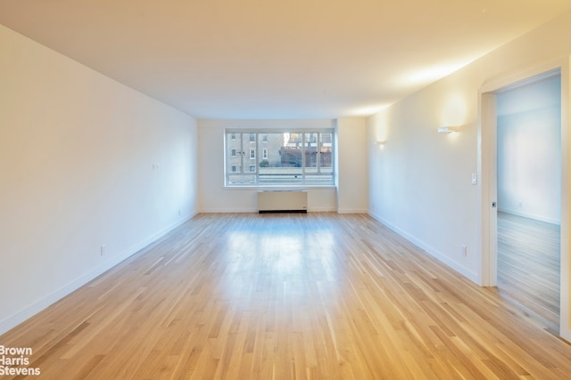 30 E 62nd St Unit 11A, New York City, NY 10065 - empty room with radiator, light wood-style floors, and baseboards