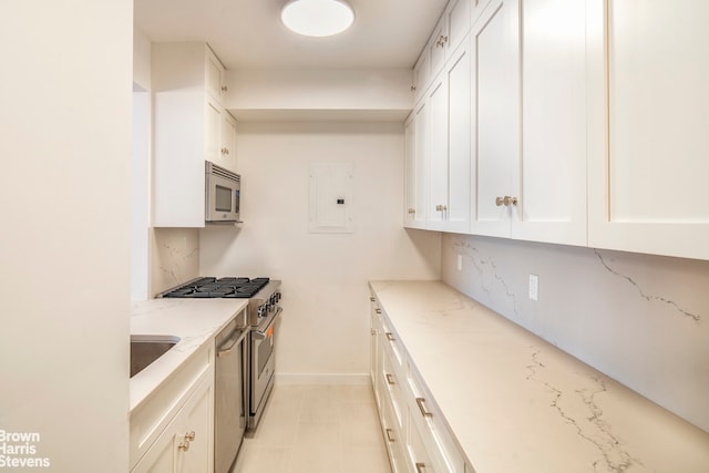 30 E 62nd St Unit 11A, New York City, NY 10065 - kitchen with stainless steel appliances, white cabinetry, light stone counters, electric panel, and baseboards