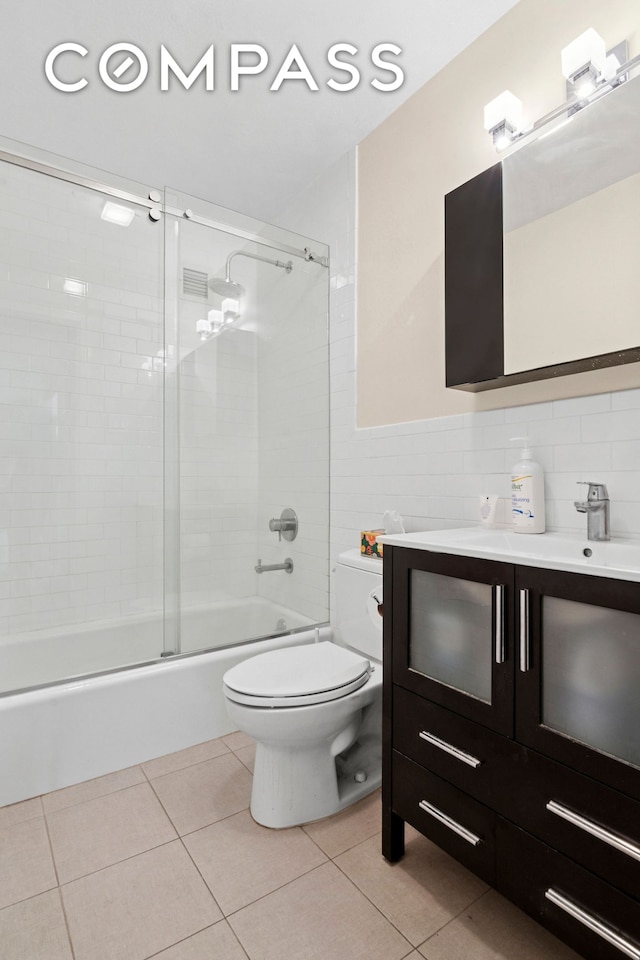 680 81st St Unit 3D, New York City, NY 11228 - bathroom featuring toilet, vanity, combined bath / shower with glass door, tile patterned floors, and tile walls