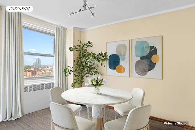 1311 Brightwater Ave Unit 14B, New York City, NY 11235 - dining area featuring radiator heating unit, a chandelier, wood finished floors, crown molding, and baseboards
