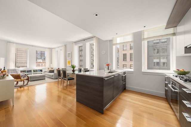 101 Leonard St Unit 6B, New York City, NY 10013 - kitchen with modern cabinets, a peninsula, dark brown cabinets, light wood-style flooring, and light countertops